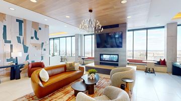 Minneapolis apartment for rent - A living room with a brown leather couch and a chandelier.