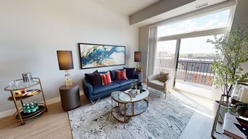 Minneapolis apartment for rent - A living room with a blue sofa and a painting on the wall.