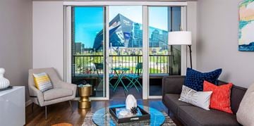 Minneapolis apartment for rent - A living room with a grey couch and a coffee table in front of a large window.