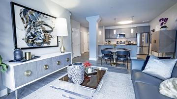 Minneapolis apartment for rent - A modern living room with a grey sofa, a coffee table, and a painting on the wall.