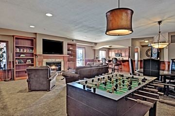 St. Cloud apartment for rent - A foosball table is in the middle of a living room with a fireplace and a television.