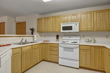 Saint Cloud apartment for rent - A kitchen with wooden cabinets and white appliances.