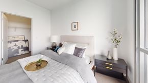 Minneapolis apartment for rent - A bedroom with a large bed and a small table with a vase on it.