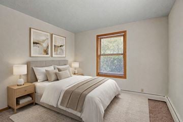 Plymouth apartment for rent - A bedroom with a bed, nightstands, and pictures on the wall.