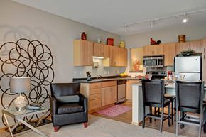 Bloomington apartment for rent - A modern kitchen with a black leather chair and a large metal sculpture on the wall.