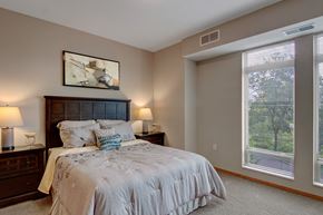 Bloomington apartment for rent - A bedroom with a large bed and a window with blinds.