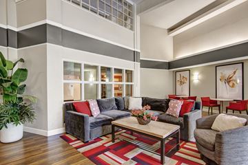 Minneapolis apartment for rent - A living room with a grey couch and a red pillow.