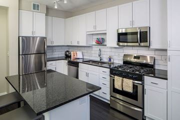 Minneapolis apartment for rent - A kitchen with white cabinets and a black countertop.