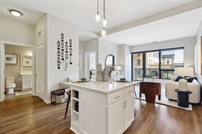 Minneapolis apartment for rent - A modern kitchen with white cabinets and a wooden floor.