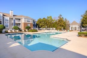 Charlotte apartment for rent - A large swimming pool in front of a building with a gazebo in the background.