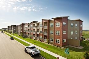Williston apartment for rent - A row of apartment buildings with a white truck parked in front of the first one.