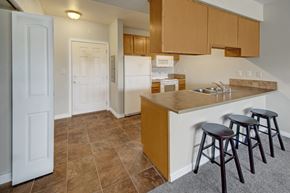 Williston apartment for rent - A kitchen with brown cabinets and a white refrigerator.