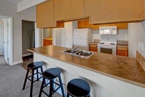 Williston apartment for rent - A kitchen with a white refrigerator, a white oven, and a white microwave.