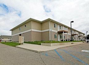 Stanley apartment for rent - Apartment building with a parking lot in front.