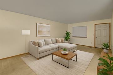 Stanley apartment for rent - A living room with a grey couch, a coffee table, and a painting on the wall.