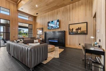 Yukon apartment for rent - A modern living room with a grey sofa and a wooden wall.
