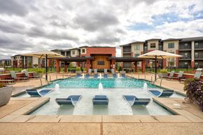 Edmond apartment for rent - A large pool with a fountain in the middle of it.
