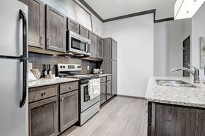 Tulsa apartment for rent - A kitchen with dark wood cabinets and stainless steel appliances.