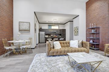 Tulsa apartment for rent - A modern living room with a white rug and a brown couch.