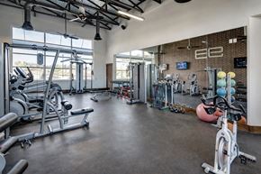 Owasso apartment for rent - A gym with a variety of exercise equipment including treadmills, weights, and exercise balls.