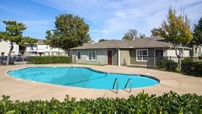 Oklahoma City apartment for rent - A swimming pool in front of a house with a fence around it.