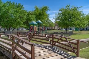 Oklahoma City apartment for rent - A wooden bridge leads to a playground in a park.