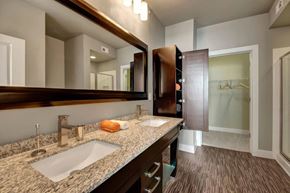 Tulsa apartment for rent - A bathroom with a double sink and a large mirror.