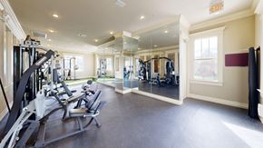 Tulsa apartment for rent - A gym with a variety of equipment including treadmills, weights, and a squat rack.