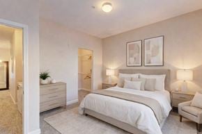 Oklahoma City apartment for rent - A bedroom with a large bed, two nightstands, and a chair.