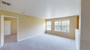 Oklahoma City apartment for rent - A spacious room with a carpeted floor and two windows.