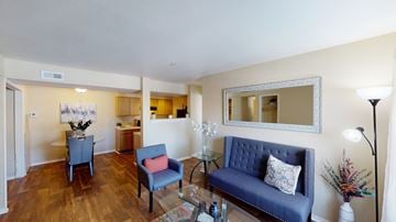 Oklahoma City apartment for rent - A living room with a blue couch and a mirror on the wall.