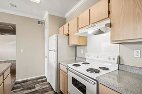Oklahoma City apartment for rent - A kitchen with a white stove top oven and white refrigerator.