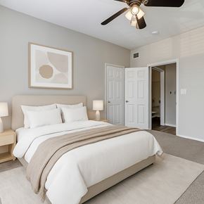 Oklahoma City apartment for rent - A bedroom with a large bed and a ceiling fan.