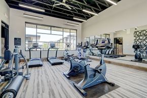 Oklahoma City apartment for rent - A fitness center here at The Encore with cardio machines, mirrored walls, and large windows. The open layout feels bright and modern, with high ceilings and natural light creating an energizing workout space.