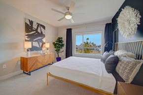 Oklahoma City apartment for rent - A bedroom with a bed, a dresser, and a ceiling fan.
