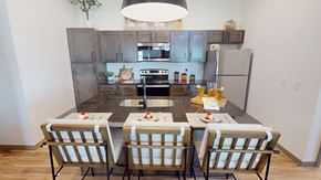 Yukon apartment for rent - A kitchen with a table set for two with a sink and refrigerator in the background.