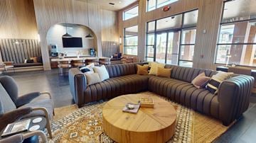 Yukon apartment for rent - A living room with a large couch and a television.