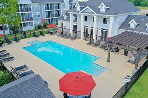 Moore apartment for rent - A red umbrella is on a patio next to a pool.