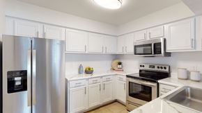 Owasso apartment for rent - A kitchen with white cabinets and stainless steel appliances.