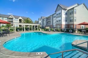 Owasso apartment for rent - A large swimming pool in front of apartment buildings.