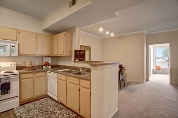 Broken Arrow apartment for rent - A kitchen with wooden cabinets and a white stove.