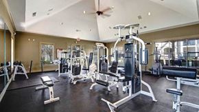 Broken Arrow apartment for rent - A spacious gym with a variety of equipment including treadmills, weight machines, and benches.