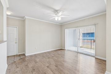 Broken Arrow apartment for rent - A room with a ceiling fan and sliding glass doors.