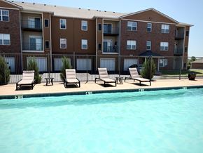 Oklahoma City apartment for rent - A large apartment complex with a pool in front.
