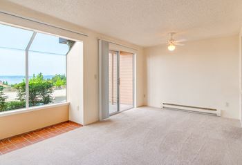 Dining area with ceiling fan, bay windows, and sliding glass door out to a balcony