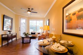 Odessa apartment for rent - A warm and inviting living and dining area at Andalucia Villas featuring wood-style flooring, large windows with natural light, ceiling fan, and an open layout that feels comfortable and welcoming.