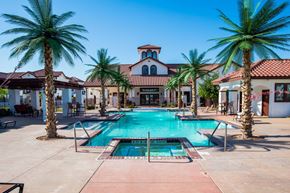 Odessa apartment for rent - A resort-style swimming pool here at Andalucia Villas with clear blue water, a central spa, and palm trees lining the deck, surrounded by lounge seating and Spanish-style buildings that create a relaxing, upscale atmosphere.