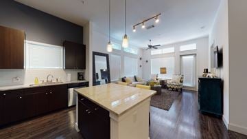 Dallas apartment for rent - A modern kitchen with dark wood cabinets and a white island.