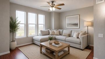 Garland apartment for rent - A living room with a white couch, a wooden coffee table, and a ceiling fan.