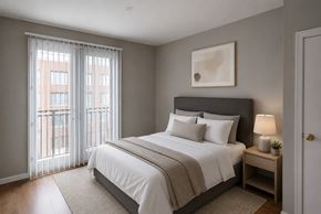 Garland apartment for rent - A bedroom with a large bed and a window with curtains.